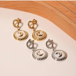 Detailed macro of gold and silver steel earrings with crescent moon mother of pearl inlay