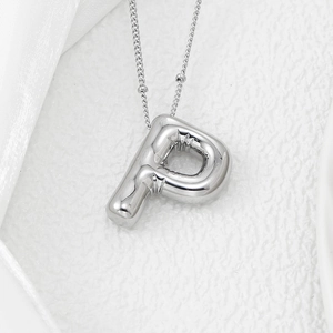 Close-up of silver balloon style letter P pendant with puffy metal texture on fine chain
