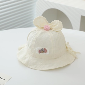 Detail of baby sun hat with bunny ears bow and textured fabric on white background