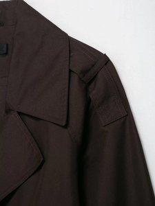 Close-up of shoulder epaulettes and stitching on chocolate brown cropped trench coat