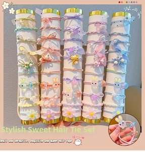 Macro shot of assorted colorful macaron hair ties with cartoon rabbit and floral charms