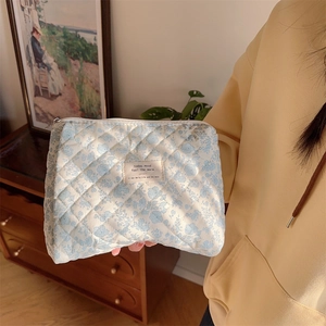 Close-up of quilted floral cotton makeup bag with blue flowers and smooth zipper