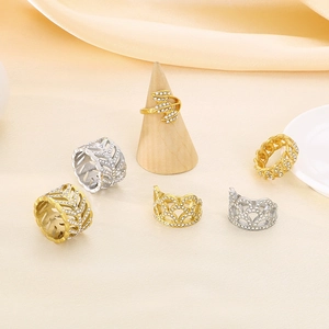 Detailed view of hollow leaf and crown rings with cubic zirconia on silk fabric