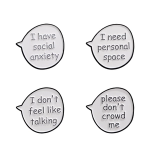 Set of four white speech bubble enamel pins with social anxiety and personal space text