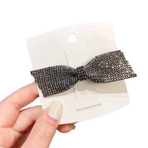 Sparkling dark rhinestone bow hair clip on accessories card with high-gloss finish