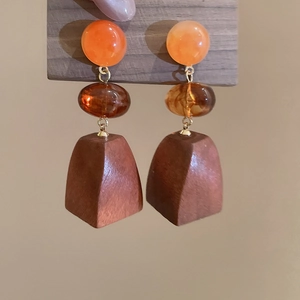 Detail of vintage geometric earrings with wood trapezoid and amber resin beads