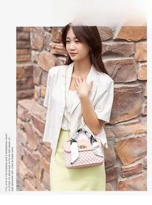 Close-up of pink printed flap bag featuring golden chain strap and floral scarf handle