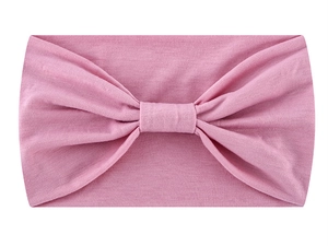 Detail view of pink knotted headband made of soft moisture-wicking fabric for yoga