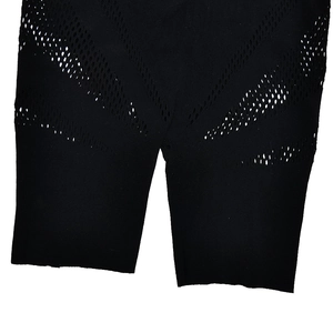 Détail du tissu en maille noire sur l'ourlet de la jambe montrant une texture élastique