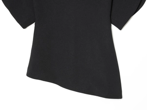 Detailed close-up of the black bubble sleeve top featuring an asymmetric hemline design