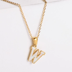 Detailed close-up of 18k gold-plated W letter pendant with white mother of pearl inlay
