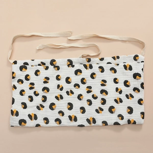 Close-up of cotton muslin crib organizer with animal print and soft ties for hanging