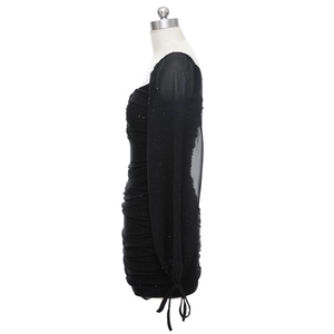 Détail des manches en tulle à paillettes et design froncé sur une robe courte noire