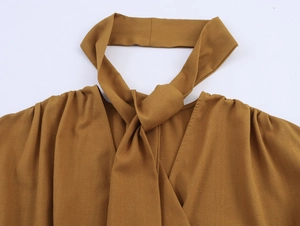 Detail view of camel halter neck top with lace splicing and elegant tie collar detail