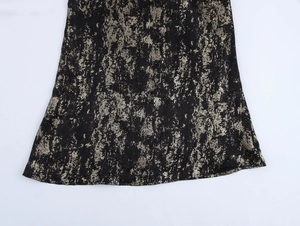 Detailed view of the black fabric featuring irregular gold textures and vintage patterns