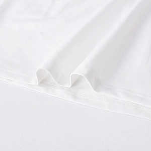 Vue détaillée de l'ourlet à double couture sur une robe blanche en maille transparente