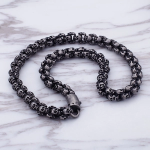 Detailed view of punk skull link chain bracelet in antique silver finish on marble