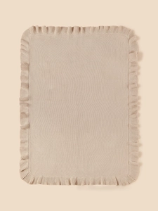 Detailed close-up of soft knitted baby blanket with delicate ruffled edges and fine texture