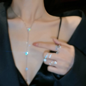 Detailed view of elegant silver Y-shaped necklace with zircon pendant worn by a model