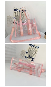 Detailed view of a clear PVC tote bag with pink nylon handles and detachable shoulder strap