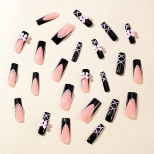 French tip press-on nails with black bows, pearls and cross line patterns on beige base
