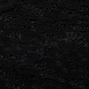 Vue macro détaillée du tissu en dentelle noire montrant la texture florale complexe
