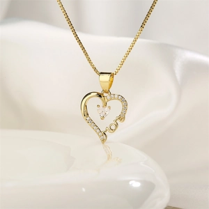 Close-up of gold heart pendant with Mom lettering and zircon stones on white silk