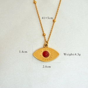 Macro view of gold sunburst evil eye necklace with red gemstone and size details