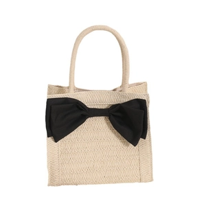 Sweet beige woven straw handbag with a large black bow for summer beach vacation style