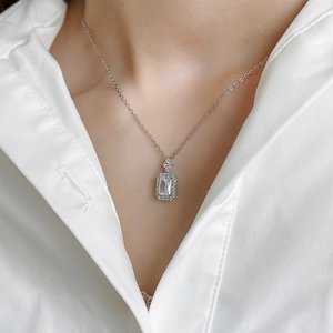 Detail of S925 silver necklace with emerald-cut zircon pendant in halo setting