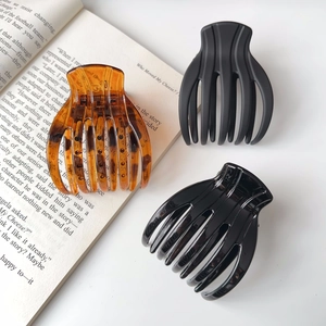 Three large elegant hair claw clips in amber, matte black and glossy black finishes