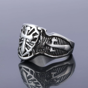 Close-up of retro stainless steel ring with cross shield engraving and oxidized finish