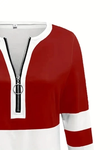 Detail of red and white patchwork sweatshirt featuring silver ring zipper and V-neckline