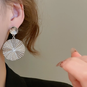 Detailed view of silver geometric double disc earrings with hammered metal texture