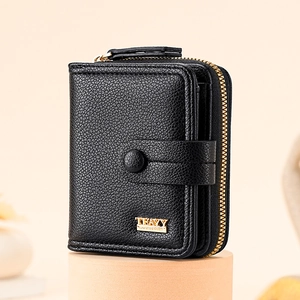 Short black litchi texture women's wallet with gold hardware on minimalist pedestal