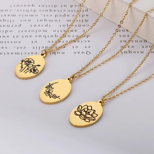 Detailed view of three gold oval flower pendants with black engraved floral patterns