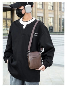 Detail of dark brown leather crossbody bag with front zipper on a male model in streetwear