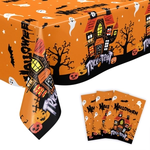 Halloween table runner with orange patterns of haunted houses, ghosts and pumpkins