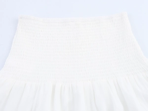 Detailed close-up of white smocked fabric texture on vacation style crop top