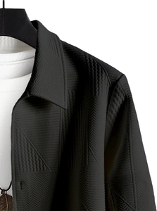 Close-up of black jacket with geometric embossed pattern and stylish turn-down collar detail