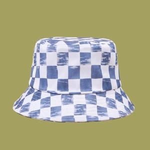 Close-up of blue checkerboard bucket hat featuring trendy tie-dye cloud patterns