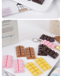 Detailed view of colorful resin chocolate charms with keychains on a white tray