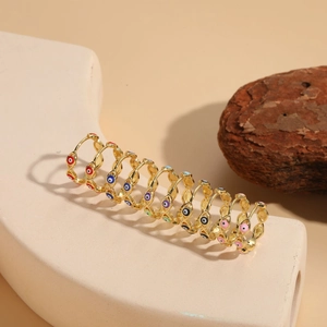 Detailed macro of golden 14K gold-plated evil eye hoop earrings in colorful enamel finish