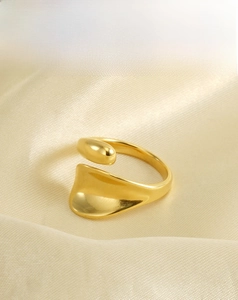 Macro shot of an 18K gold-plated stainless steel open ring on a yellow silk background