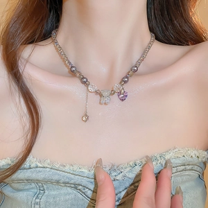 Detail view of a purple heart crystal necklace with bear pendant on beaded chain