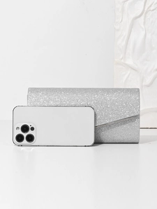 Silver glitter evening clutch bag shown next to a smartphone for size reference