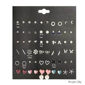 Detail of 30 pairs set showing stars, hearts and moon stud earrings on black card