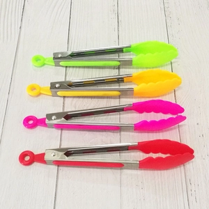 Detailed view of colorful stainless steel food tongs in green, yellow, pink and red