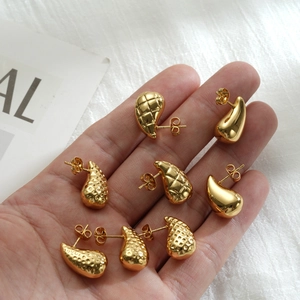 Detailed macro view of three gold teardrop studs with smooth, quilted, and hammered textures