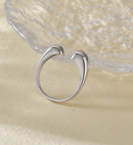Detailed view of minimalist S925 sterling silver open ring on textured glass plate